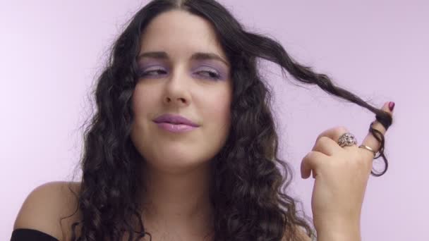 černými kudrnatými vlasy plus velikost modelu s hnědýma očima na lila pozadí s lila make-up - Záběry, video