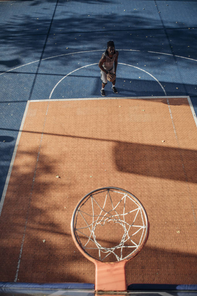 Young Caucasian man playing basketball at outdoor court. - Zdjęcie, obraz