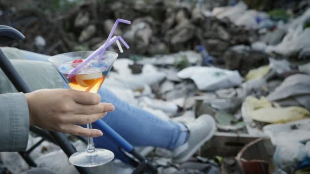 Ένα ποτήρι με ένα τοξικό υγρό, πλαστικά καπάκια στο χέρι μιας γυναίκας - Πλάνα, βίντεο