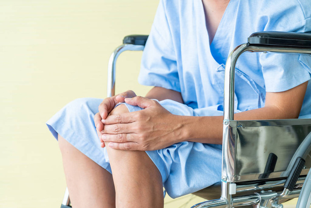 Ασίας senior αναπηρική καρέκλα ασθενών με πόνο στο γόνατο - επιλεκτική εστίαση σημείο - Φωτογραφία, εικόνα
