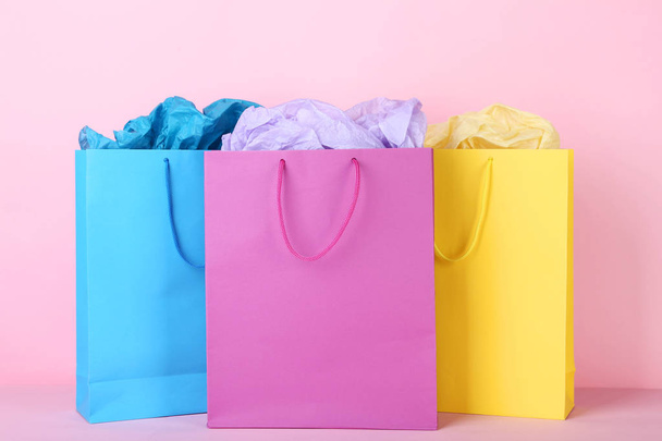 Colorful shopping bags with paper on pink background - Foto, Imagen