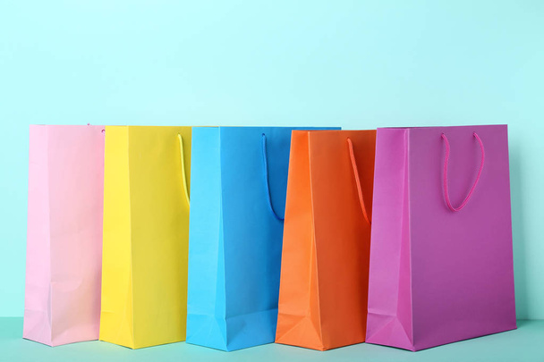 Colorful paper shopping bags on mint background - Фото, изображение