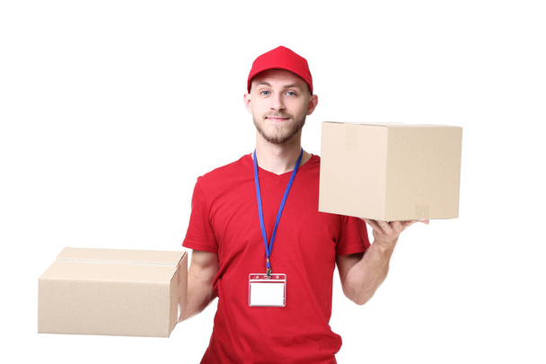 Delivery man with cardboard boxes standing on white background - Фото, изображение