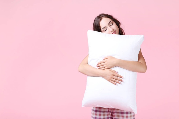 Beautiful girl holding white pillow on pink background - Valokuva, kuva