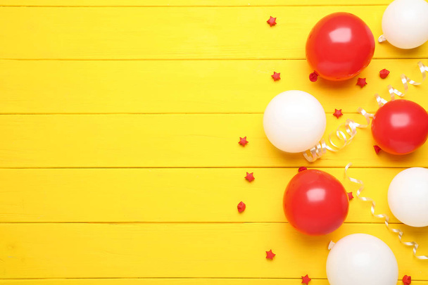 red and white balloons with paper stars on yellow wooden background - Fotó, kép