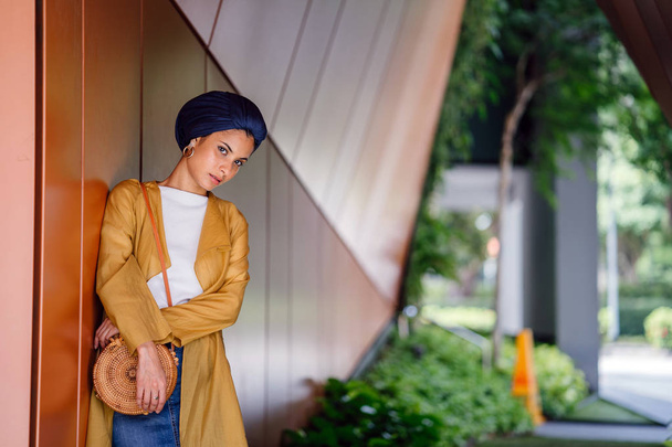 Fashion portrait of a tall, slim, young and attractive Malay Muslim woman wearing fashionable clothing and a turban - 写真・画像