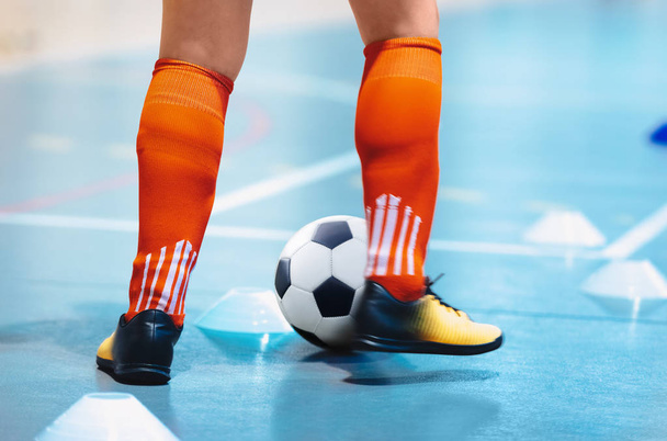 Futsal league. Indoor soccer player in futsal shoes training dribble drill with ball. Indoor soccer training. Running futsal player, soccer ball, white cones. Indoor football player with classic ball. - Photo, Image