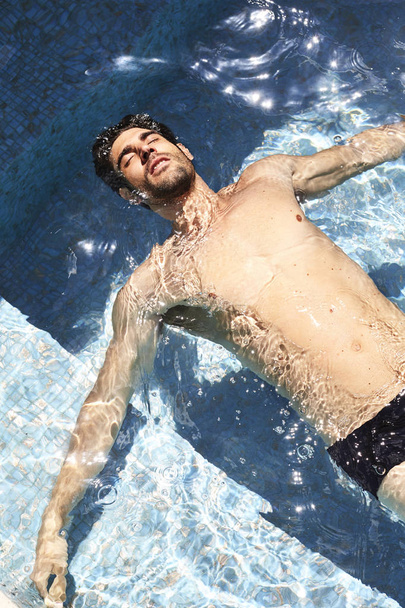 Pihentető srác medencében fekvő - Fotó, kép