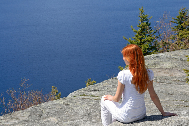 Ragazza seduta su una roccia, godendo la vista
 - Foto, immagini