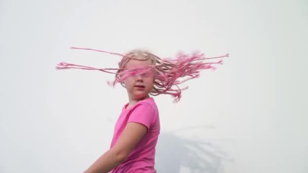 Краса повільний рух - портрет красиві світлошкірих маленькою дівчинкою з нестандартними сучасний зовнішній вигляд - з рожевими Африканські косички Зізі - Кадри, відео