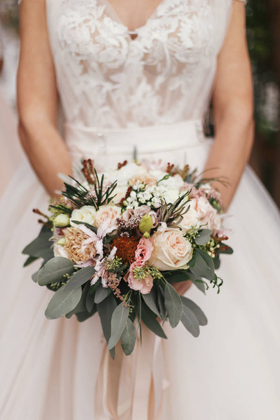 スタイリッシュなウェディング ブーケをモダンなドレスの背景につかまって豪華な美しい花嫁。結婚式の装飾 - 写真・画像