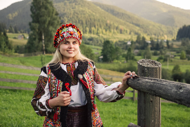 Όμορφη καυκάσιος γυναίκα που φοράει εθνοτικές και παραδοσιακή του ρούχα Ουκρανικά Καρπάθια βουνό. Χωριό με φόντο το φθινόπωρο. - Φωτογραφία, εικόνα