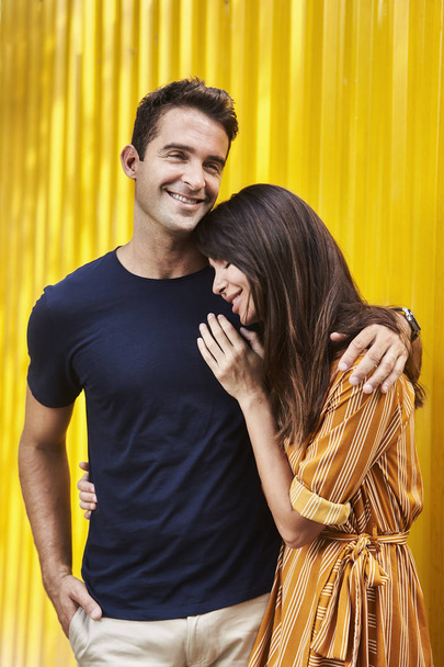 Laughing couple by yellow wall - Foto, Imagem