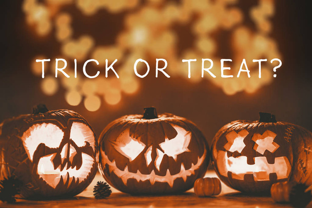 Caption trick or treat on the photo of three spooky jack-o'-lanterns made for halloween - Fotó, kép