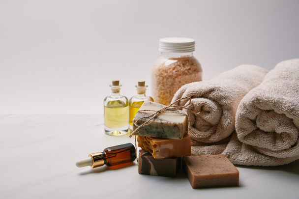 Handgefertigte Seife mit verschiedenen Massagemitteln auf weißem Marmor - Foto, Bild