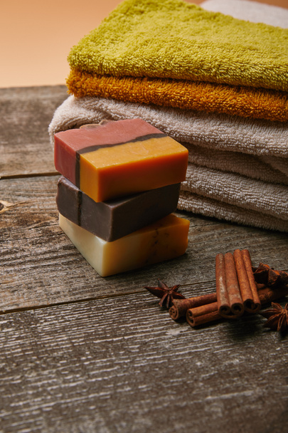close-up shot of soap pieces with stacked towels and spices on rustic wooden tabletop - Foto, immagini