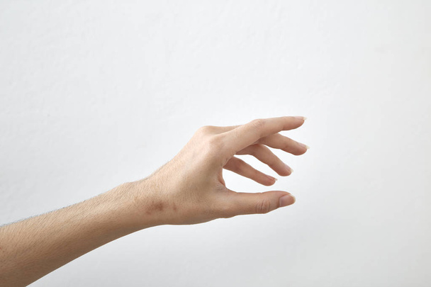 Vista lateral de la hermosa palma de la mano femenina derecha relajada con manicura neutra sobre fondo blanco. primer plano estudio disparo
. - Foto, Imagen