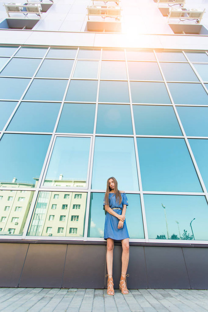 Retrato urbano de moda de modelo hermoso en la calle. Joven mujer delgada con vestido azul en la ciudad
 - Foto, Imagen