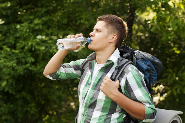 Hiker drinking water in forest - Foto, imagen