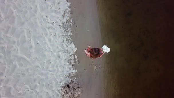 aantrekkelijke jonge vrouw is lopen op een zand van de rivier bank - Video