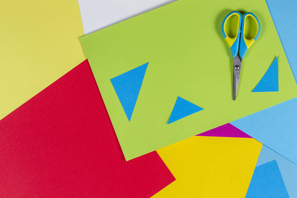 Вид зверху кольоровий папір з різнокольоровими ножицями. Дитячий художній та ремісничий паперовий фон
 - Фото, зображення