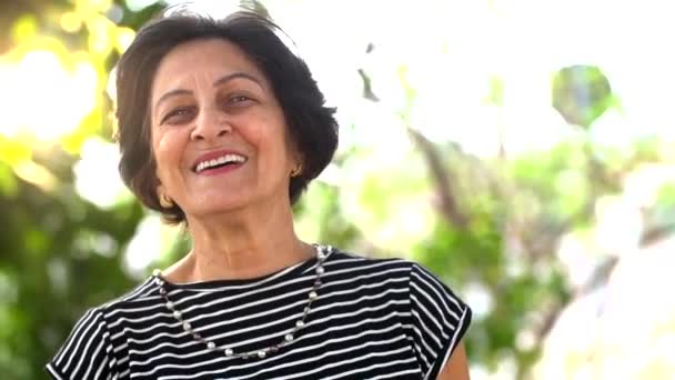 Portrait of senior brazilian woman looking at camera in sunset and smiling. Horizontal shape, copy space - Filmagem, Vídeo
