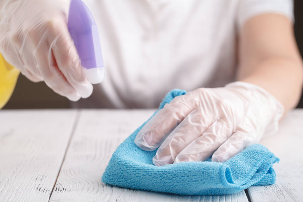 Hand in a rubber glove holds spray bottle of liquid detergent on. cleaning - 写真・画像