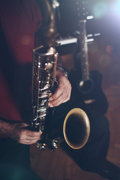 Close up shot of musician playing saxophone. Low light and selective focus. - Photo, image