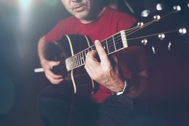 Close up shot of musician playing guitar. Low light and selective focus. - Фото, изображение