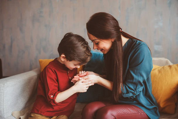 indoor portrait of happy mother and child son sitting on couch and playing. Family life concept - Fotó, kép
