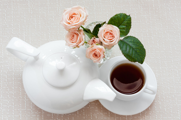 Théière, tasse et roses sur une assiette
 - Photo, image