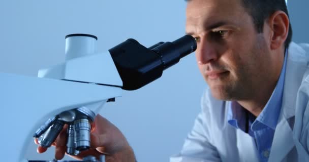 Close-up of male scientist using microscope in laboratory 4k - Imágenes, Vídeo