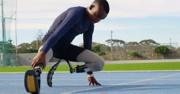 Disabled athletic exercising on a running track at sports venue 4k - Filmati, video