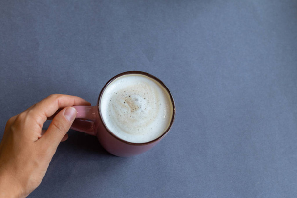 hand holding cup of coffee on wooden background - Φωτογραφία, εικόνα