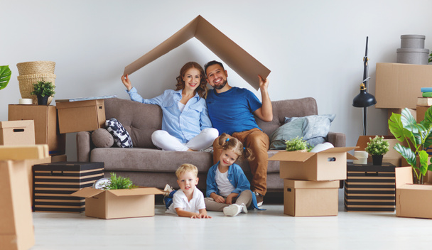 mutlu aile anne baba ve çocuk yeni bir eve taşınmak ve kutusu used açmak - Fotoğraf, Görsel