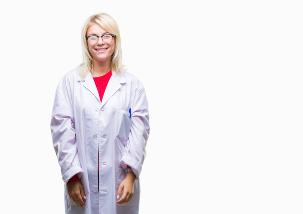 Young beautiful blonde professional woman wearing white coat over isolated background with a happy and cool smile on face. Lucky person. - Foto, Bild