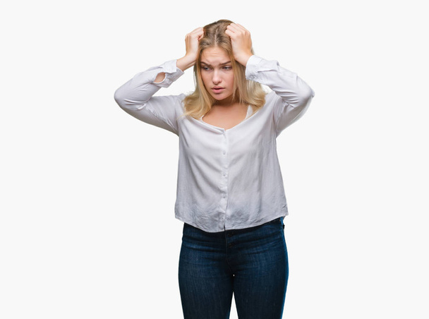 Young caucasian woman over isolated background suffering from headache desperate and stressed because pain and migraine. Hands on head. - Foto, Bild