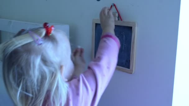 lány dörzsöli neki merítve egy fekete tábla - Felvétel, videó