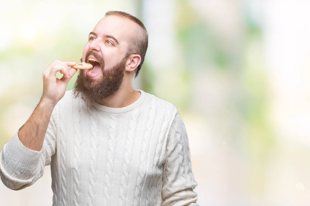 jovem hipster homem comer chocolate chips de biscoito sobre fundo isolado com uma expressão confiante no rosto inteligente pensando sério
 - Foto, Imagem