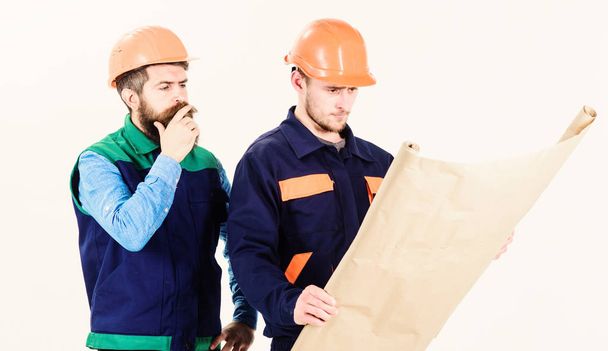 Construction plan concept. Architects in hard hat on thoughtful faces - 写真・画像