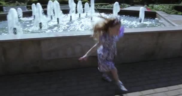Girl baby running near the fountain - Felvétel, videó