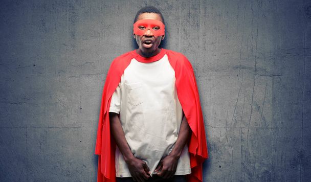 Africano negro super héroe hombre asustado en shock, expresando pánico y miedo
 - Foto, Imagen