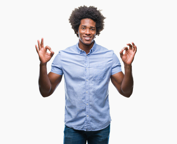 Αφρο αμερικανικό άνθρωπος πέρα από το απομονωμένο υπόβαθρο Χαλαρώστε και χαμογελαστός, με τα μάτια κλειστά να κάνει διαλογισμό κίνηση με τα δάχτυλα. Έννοια της γιόγκα. - Φωτογραφία, εικόνα