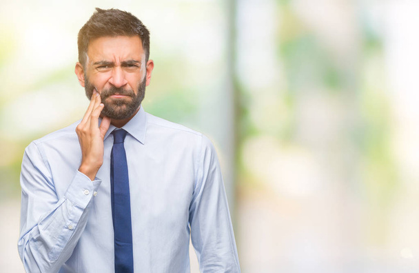 Adult hispanic business man over isolated background touching mouth with hand with painful expression because of toothache or dental illness on teeth. Dentist concept. - Foto, Imagen