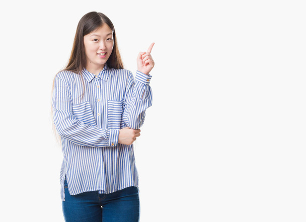 Young Chinese woman over isolated background with a big smile on face, pointing with hand and finger to the side looking at the camera. - Foto, Imagen