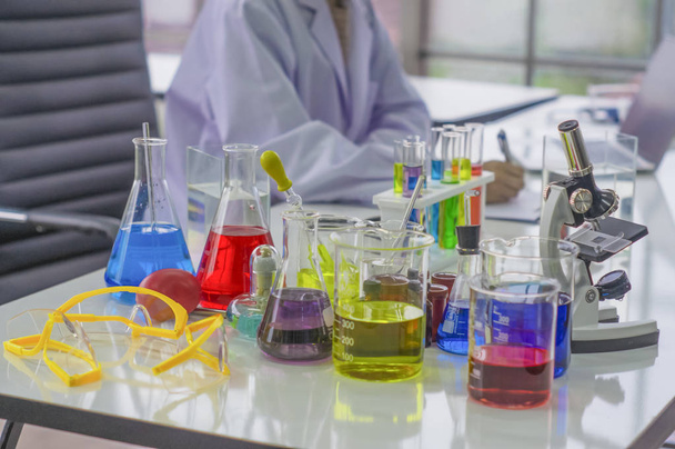 Chemiker arbeiten morgens im Labor mit Teststücken, die mit bunten Flüssigchemikalien arbeiten, Glasröhren für Kosmetika entwickeln sichere Rezepte für Verbraucher. - Foto, Bild