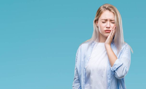 Young blonde woman over isolated background touching mouth with hand with painful expression because of toothache or dental illness on teeth. Dentist concept. - Photo, Image