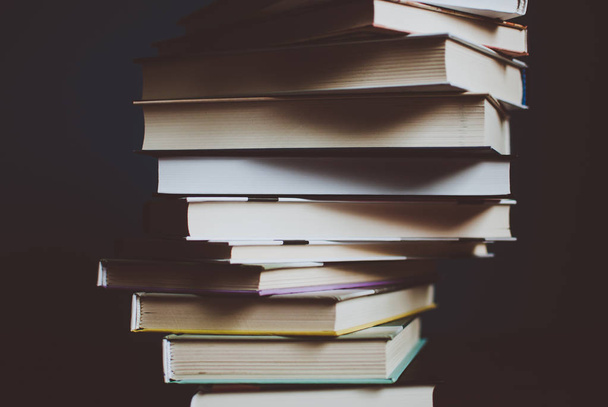 Πύργος από πολύχρωμα βιβλία πάνω στο τραπέζι. Closeup των σελίδων. Αφηρημένη έννοια της γνώσης, εκπαίδευσης, μάθησης και λογοτεχνία. Φίλτρο - Φωτογραφία, εικόνα