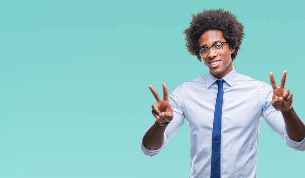 Afro Amerikaanse zakenman bril over geïsoleerde achtergrond glimlachend op zoek naar de camera vingers doen overwinning teken tonen. Nummer twee. - Foto, afbeelding