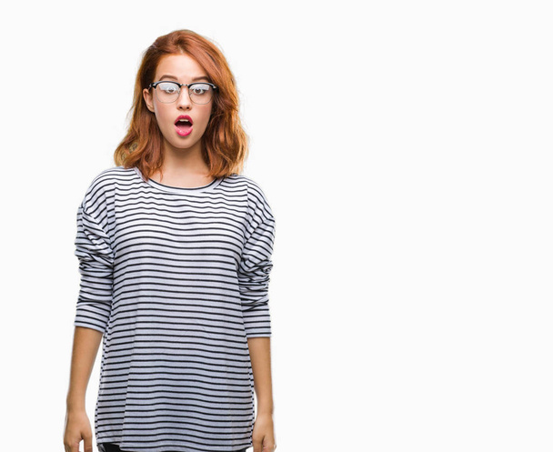 Young beautiful woman over isolated background wearing glasses afraid and shocked with surprise expression, fear and excited face. - Photo, Image